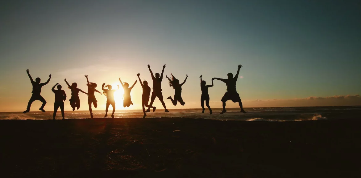 spécialisations : photo d'un groupe de personnes joyeuses sautant devant un couché de soleil