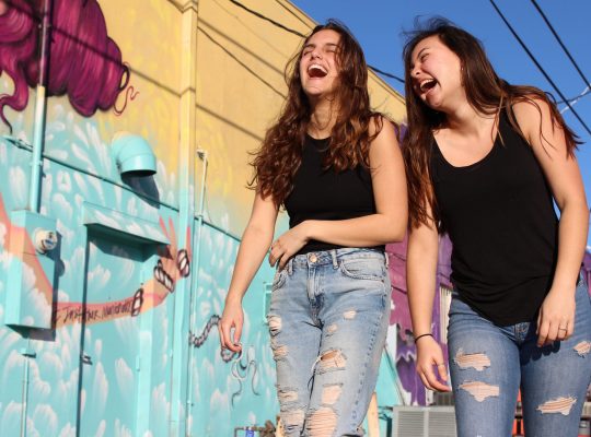 Photos de deux adolescentes qui rient entre amies. Elles font preuve d'humour dans la rue.