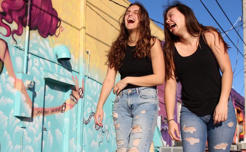 Photos de deux adolescentes qui rient entre amies. Elles font preuve d'humour dans la rue.