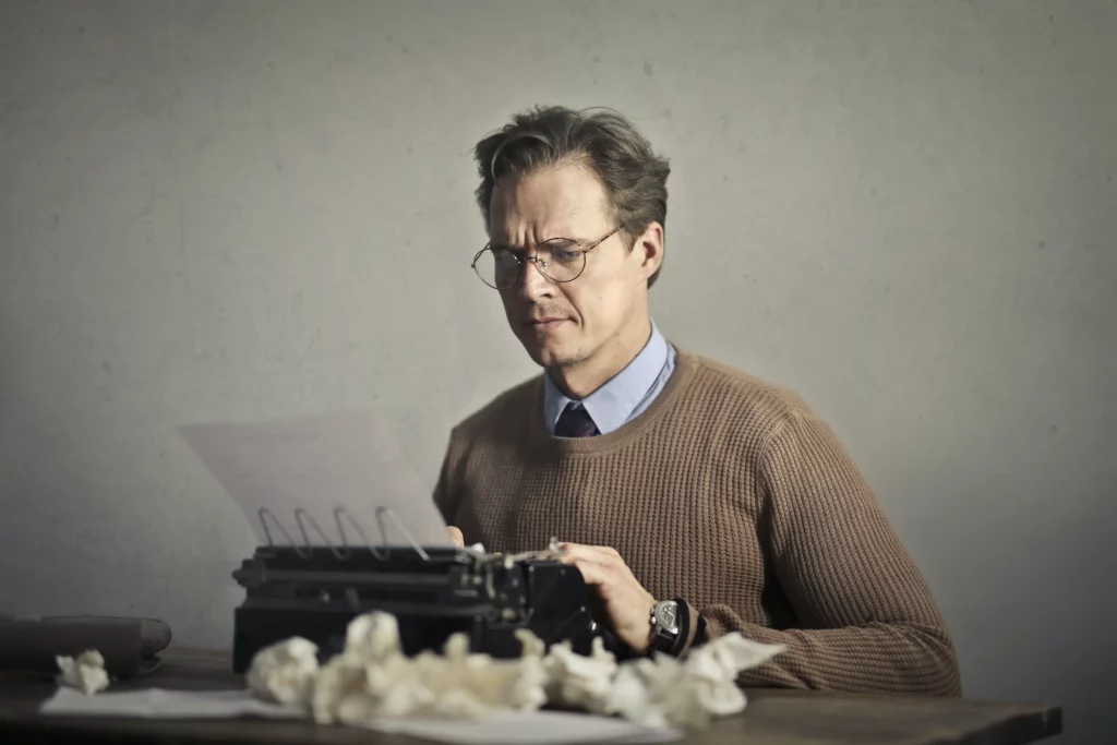 ¨Photo d'un homme à lunettes qui tape sur une machine à écrire. symbolisation et littérature.