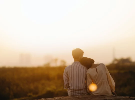 couple goals : photo d'un couple se câlinant, assis devant un coucher de soleil