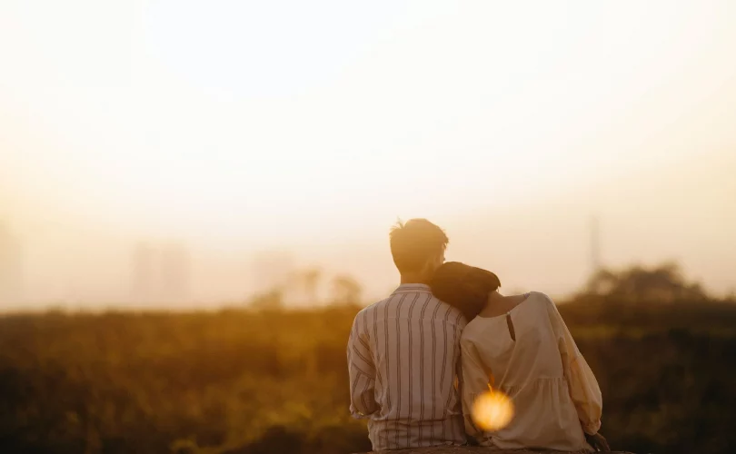 couple goals : photo d'un couple se câlinant, assis devant un coucher de soleil