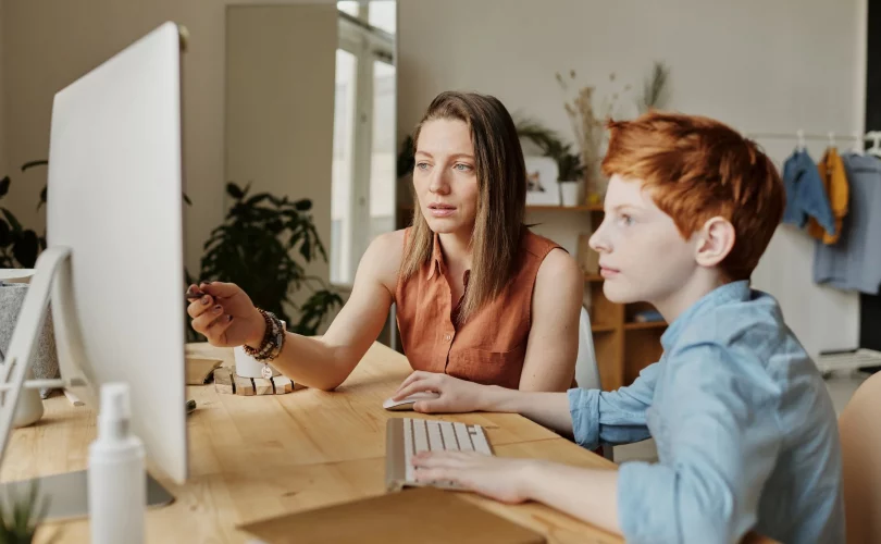 enfant surdoué en train de prendre des cours d'informatique avec une prof