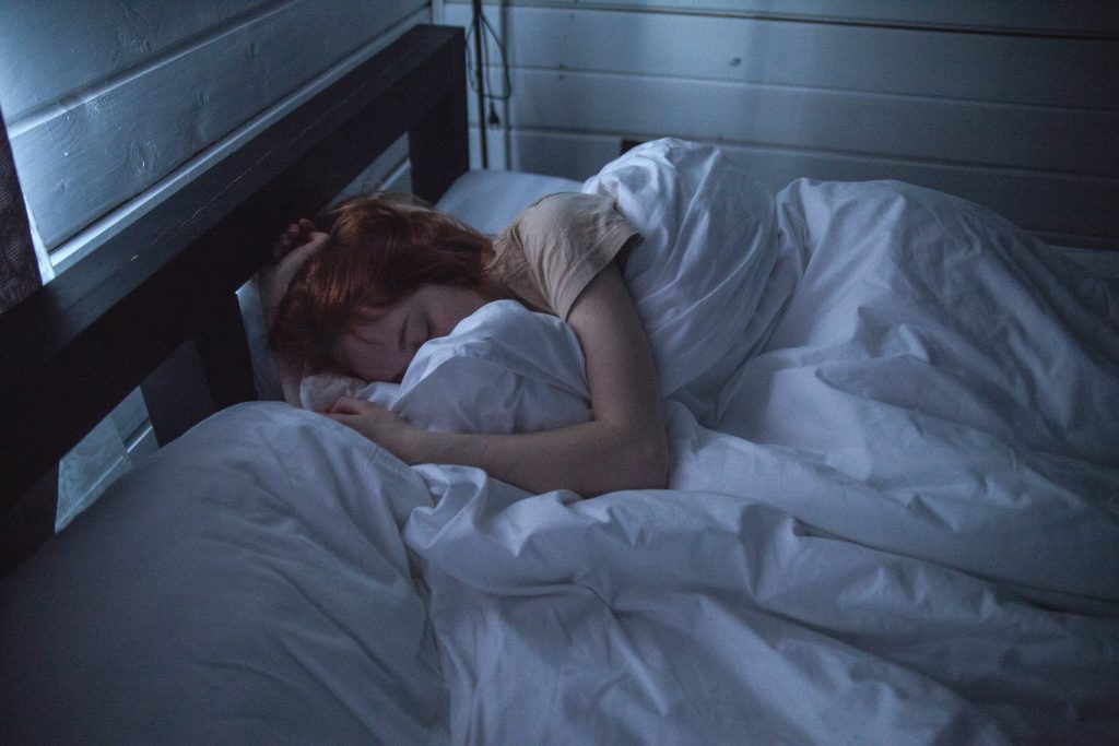 HPI et sommeil : jeune fille rousse dans son lit, qui dort paisiblement