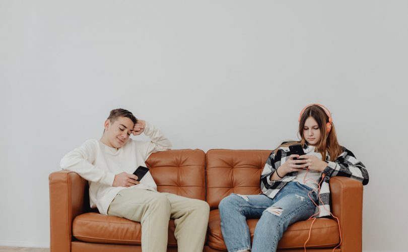Deux adolescents sur un canapé en pleine procrastination