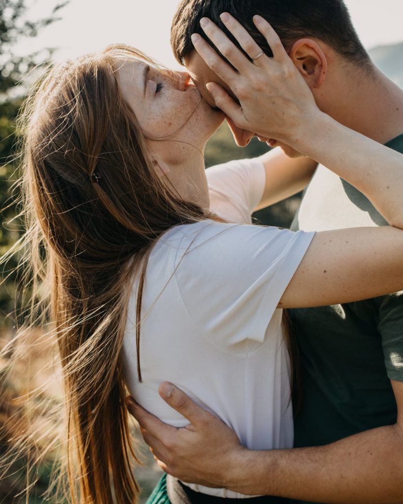 deux adolescents : une femme aux tâches de tousseur embrasse un jeune homme dans la nature, après avoir reçu une saine éducation sexuelle