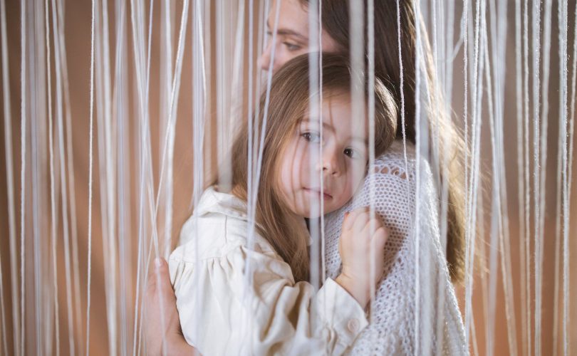 Photo d'une petite fille HPE dans les bras de sa maman