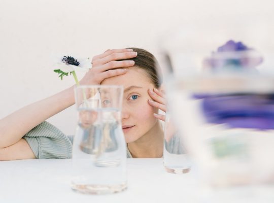 Neuroatypiques : photo d'une jeune femme neuroatypique en train de regarder au travers d'objets en verre