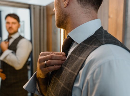 Photo d'un homme en costume qui pratique devant son miroir l'autocompassion